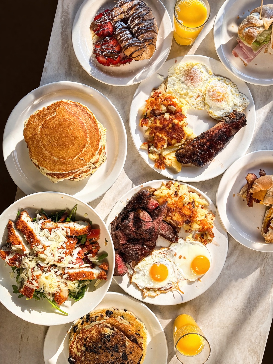 Brunch spread — pancakes, eggs, steak and salad